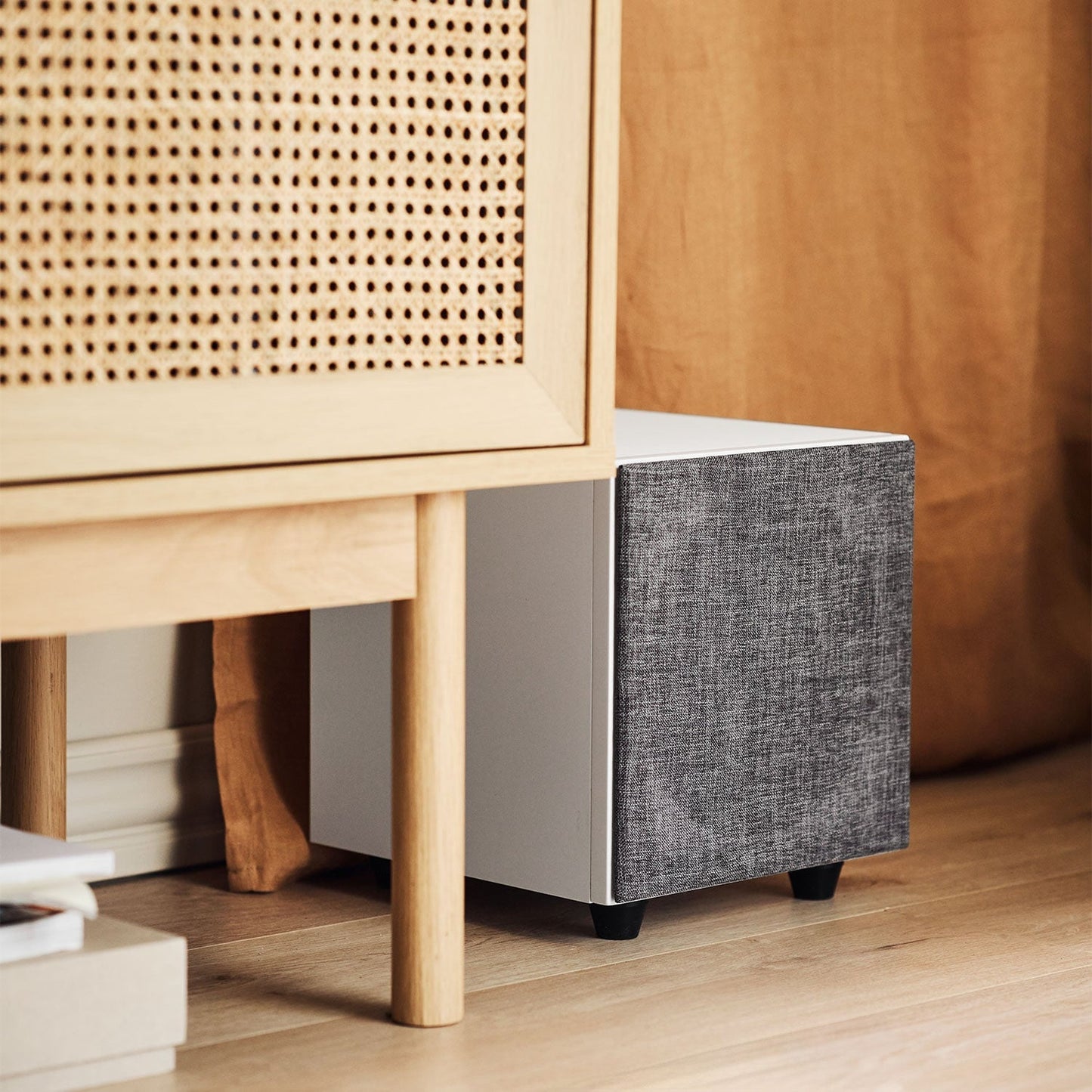 Argon Audio Malmö Sub 8 Aktiv-Subwoofer weiss mit montierter Frontabdeckung Lifestyle unter dem Sideboard