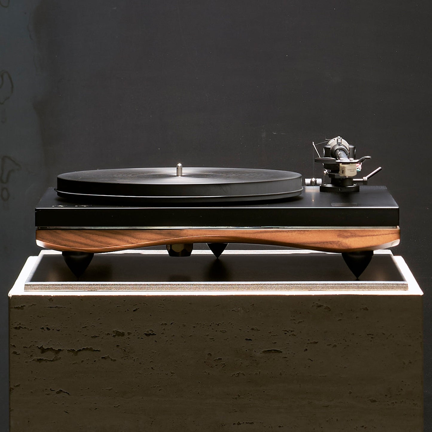 Gold Note Pianosa Plattenspieler Walnuss Lifestyle auf Betonsockel vor dunkler Wand