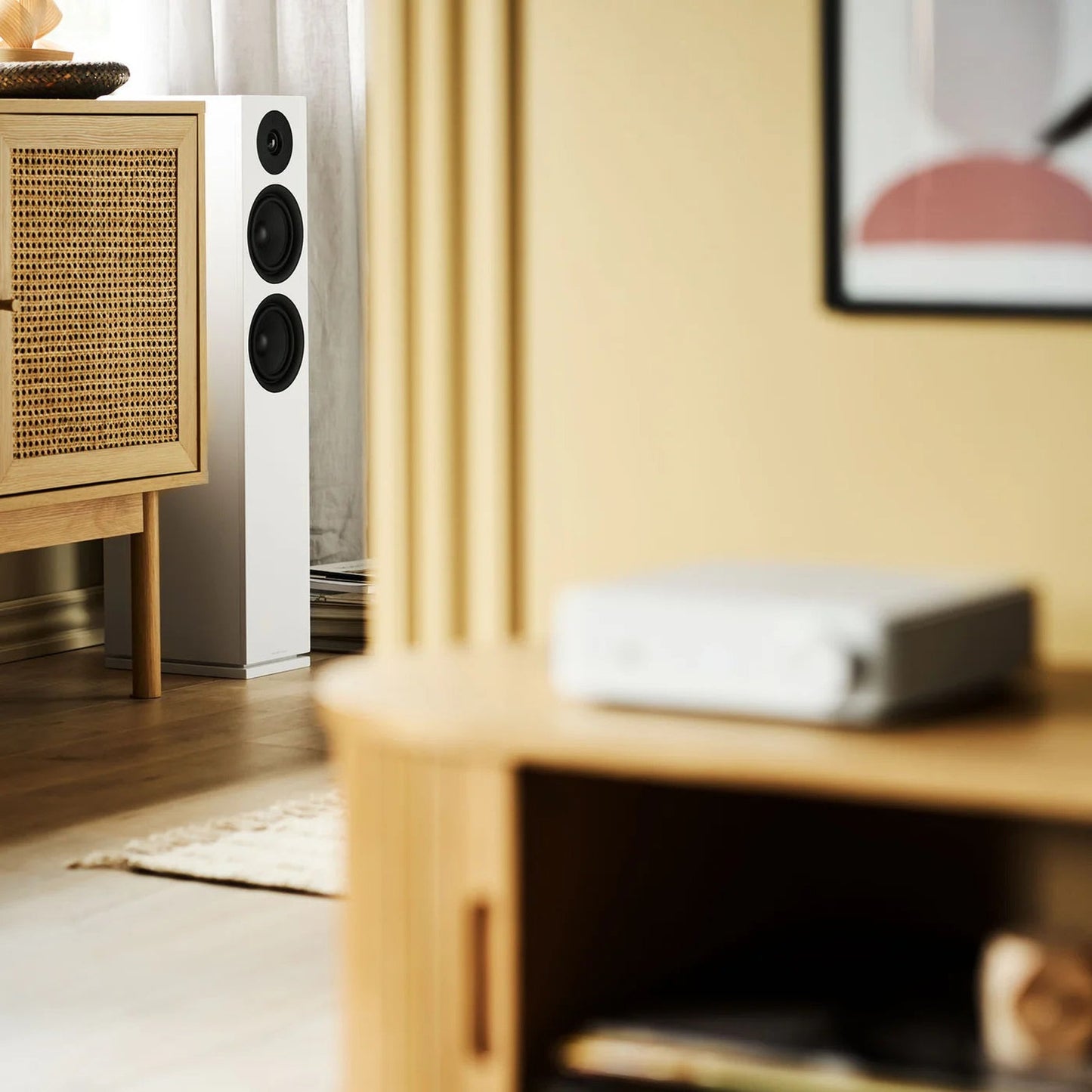 HiFi-Set Bluesound Powernode + Argon Forus 55 Weiss Lifestyle: Forus 55 im Wohnraum neben Rattan-Sideboard