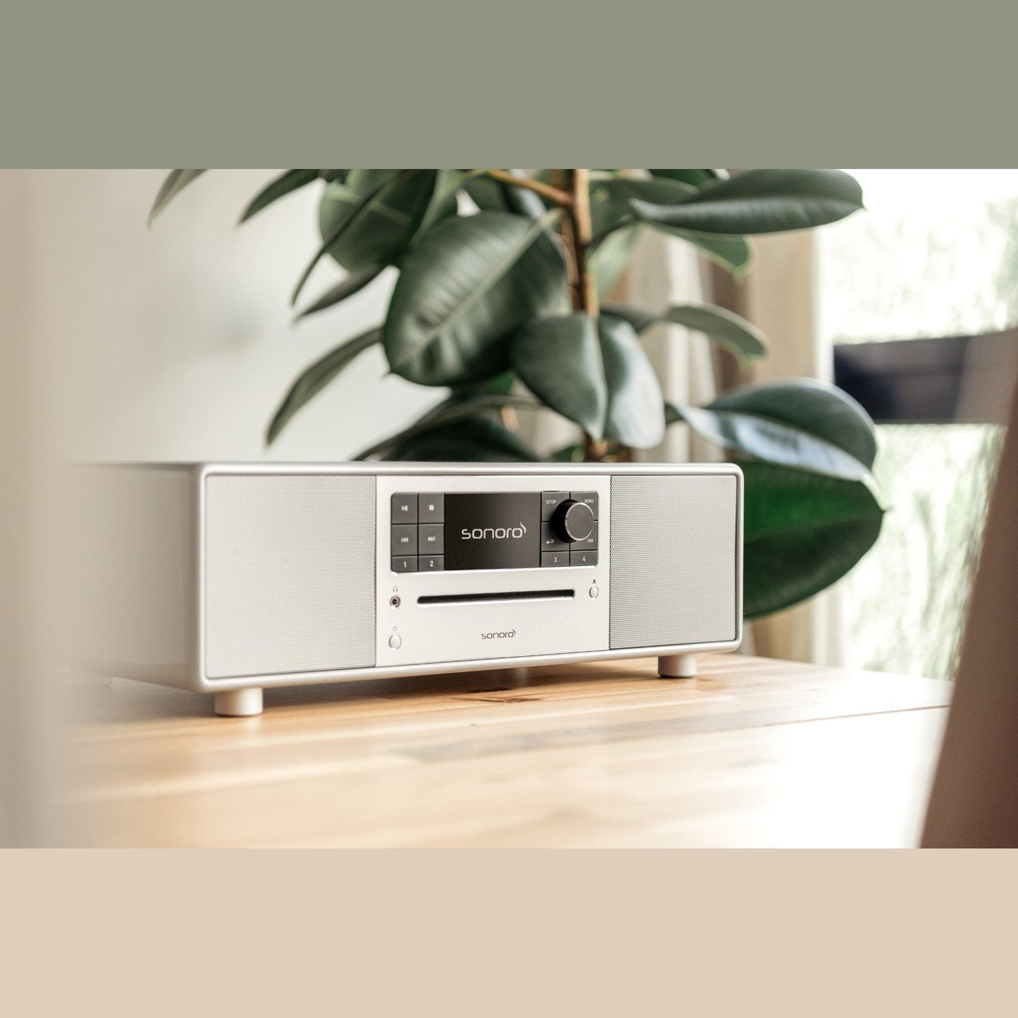 Sonoro Prestige All-in-One Lifestyle auf Holzsideboard neben Zimmerpflanze, Silber hochglänzend