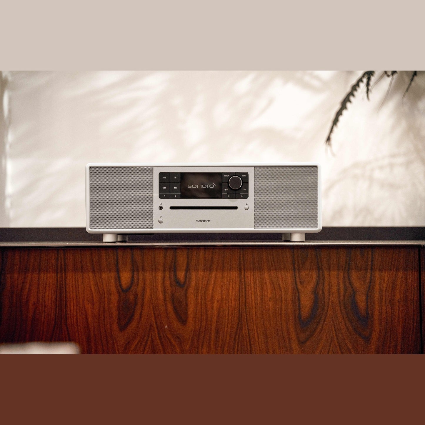 Sonoro Prestige All-in-One Lifestyle auf dunklem Holzsideboard, Weiss hochglänzend