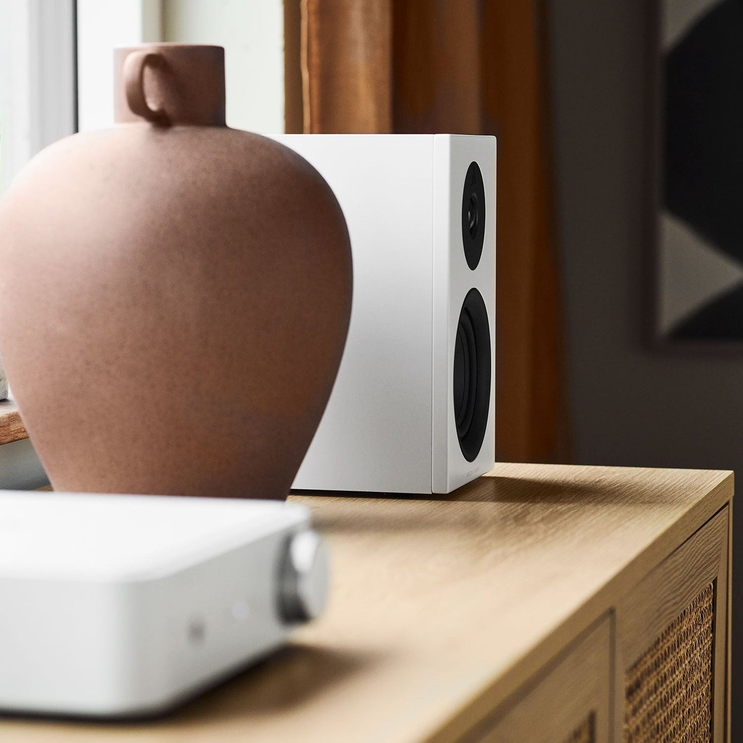 Argon Audio Forus 4 Regallautsprecher weiss Lifestyle auf der Kommode neben Vase