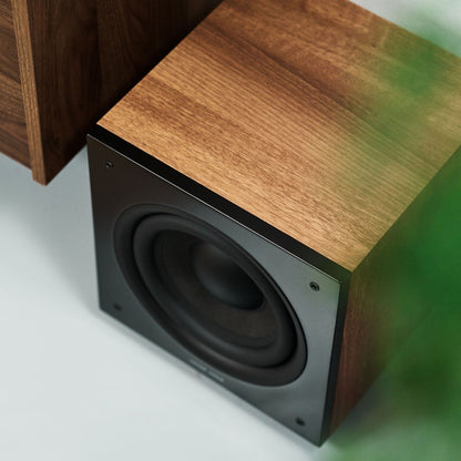 Argon Audio Malmö Sub 8 Aktiv-Subwoofer Walnuss Lifestyle unter dem Sideboard im Wohnraum