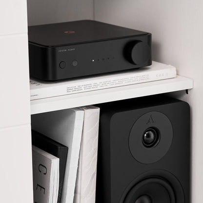 Argon Audio SA1 MK2 Vollverstärker schwarz Lifestyle auf dem Wandregal über einem Regallautsprecher