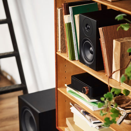 Argon Audio SA2 Streaming-Verstärker schwarz Lifestyle im Bücherregal mit Regallautsprecher und Subwoofer