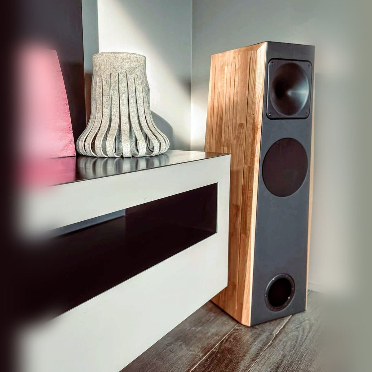 Atlantis Lab AT23 Standlautsprecher Lifestyle im Wohnraum neben weissem Sideboard