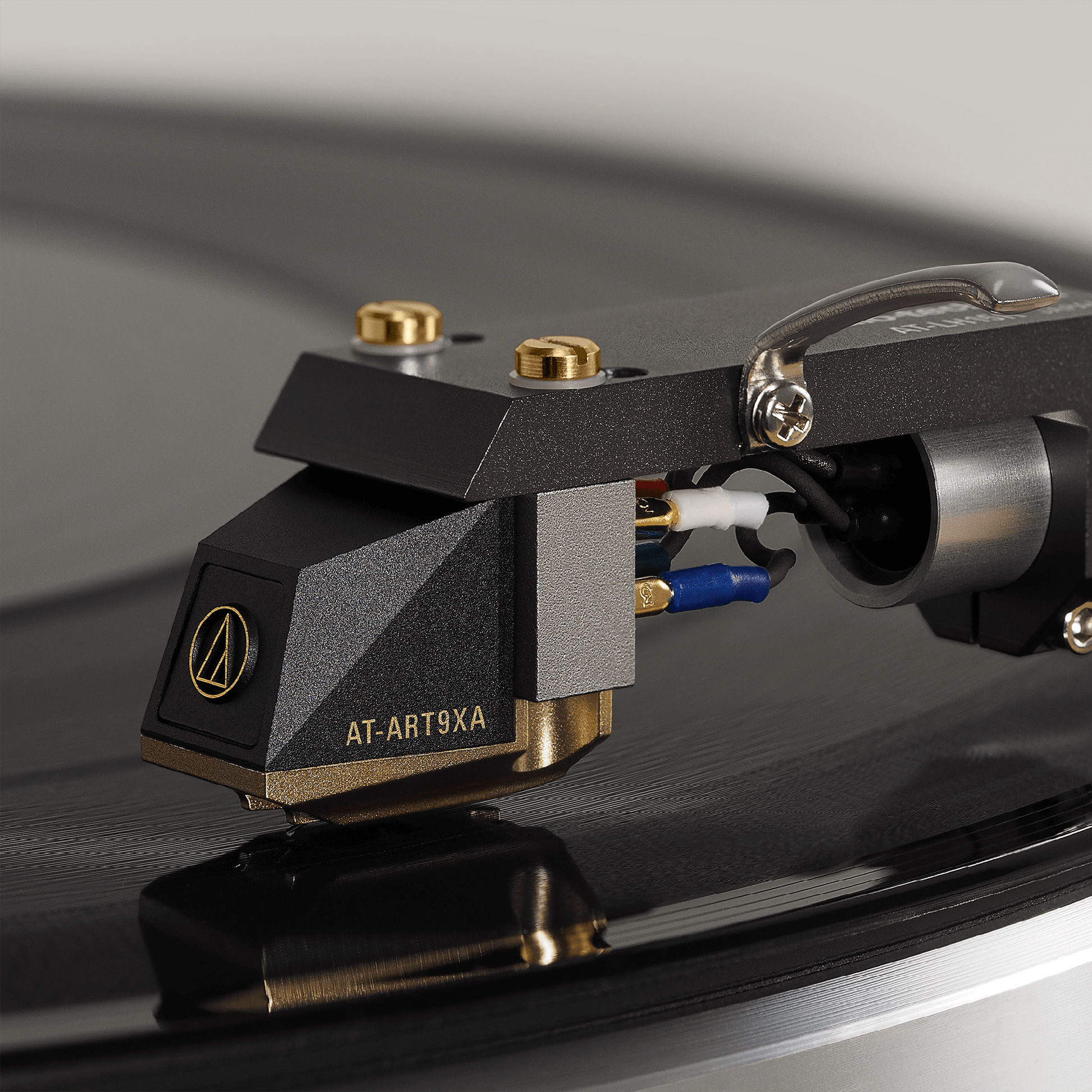 Audio-Technica AT-ART9XA MC-Tonabnehmer Detailansicht montiert am Headshell über einer Schallplatte