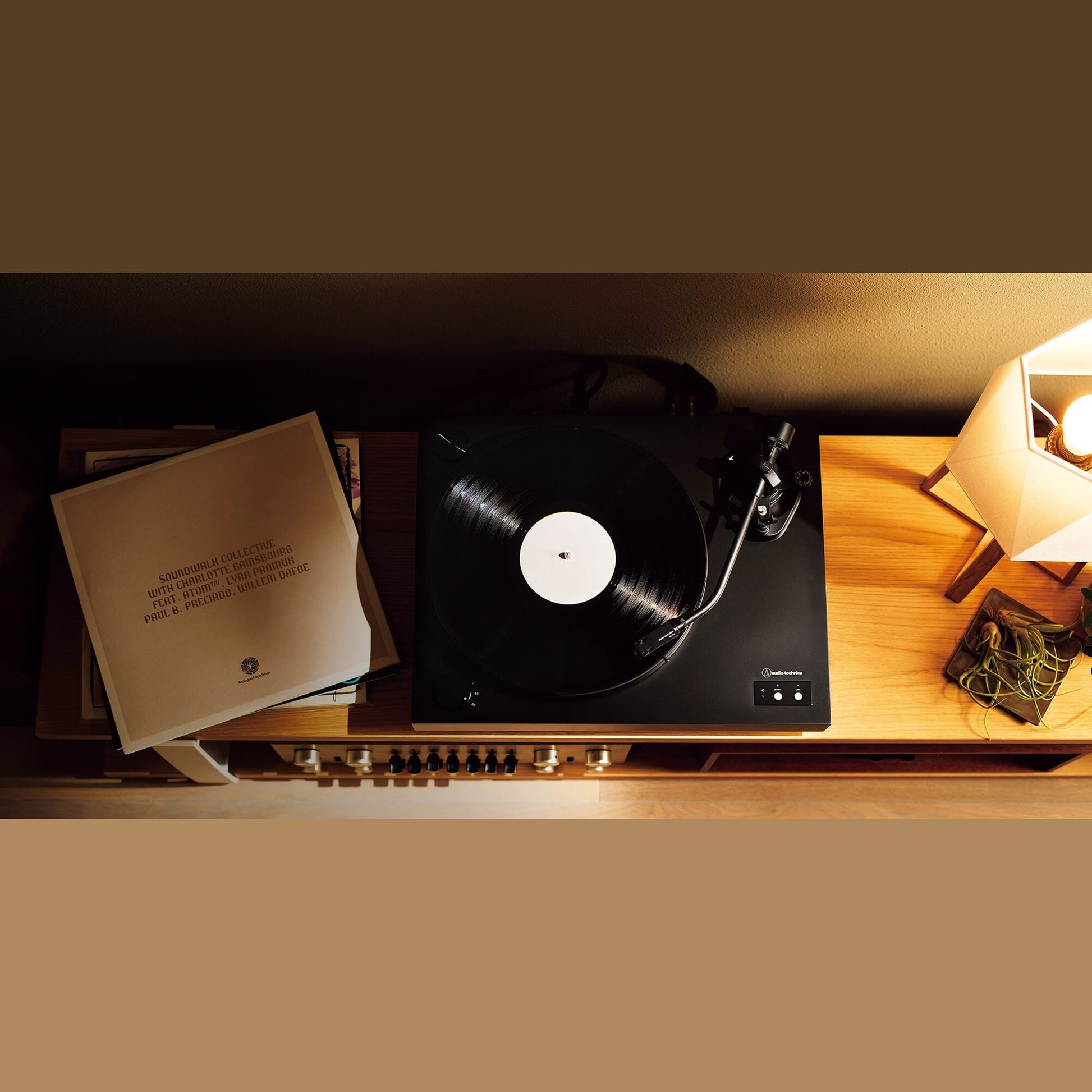 Audio-Technica AT-LP8X Plattenspieler Lifestyle mit aufgelegter Schallplatte und Plattensammlung