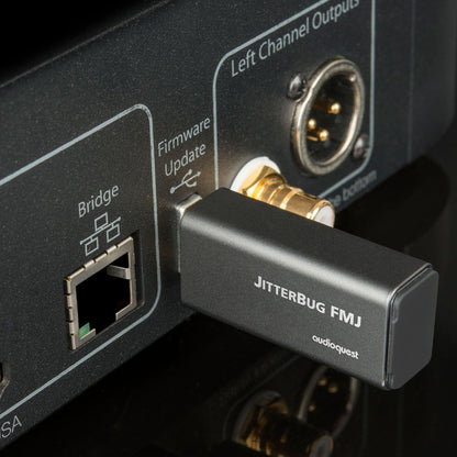AudioQuest JitterBug FMJ USB-Datenfilter Lifestyle am USB-Anschluss einer Geräterückseite neben LAN-Buchse