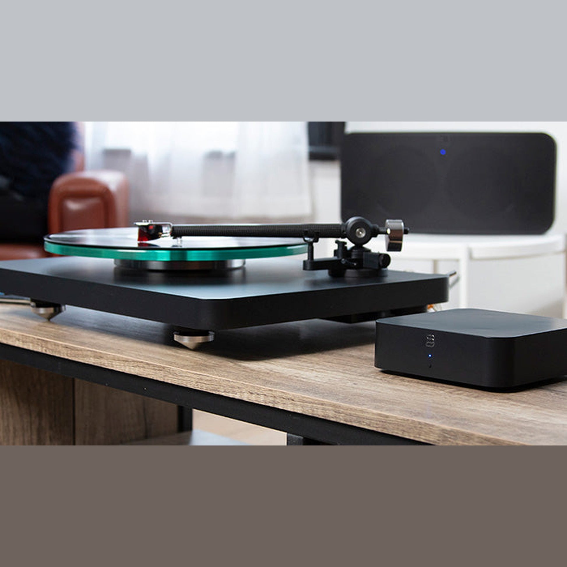 Bluesound Hub Multiroom-Streaming-Hub Lifestyle neben Plattenspieler im Wohnraum