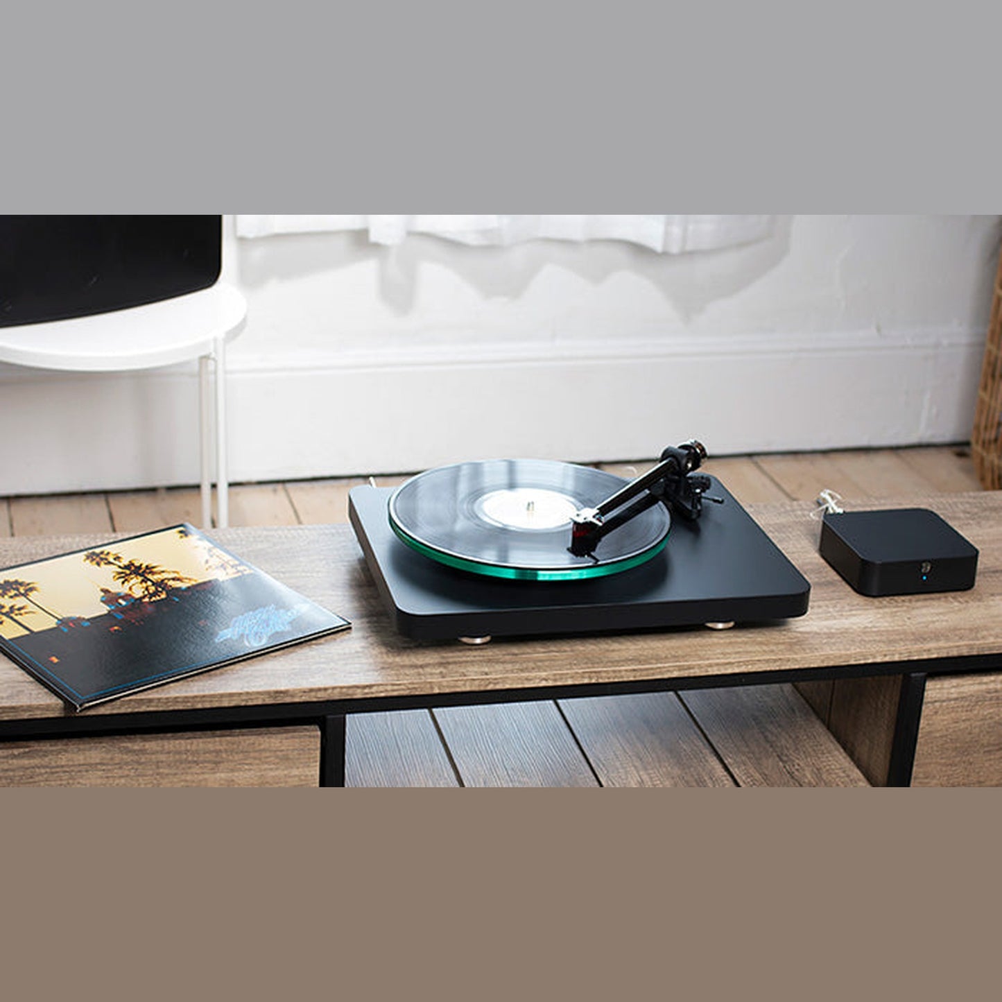 Bluesound Hub Multiroom-Streaming-Hub Lifestyle auf Beistelltisch neben Plattenspieler