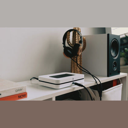Bluesound Node Netzwerk-Streamer Weiss Lifestyle auf Schreibtisch neben Kopfhörer und Regallautsprecher