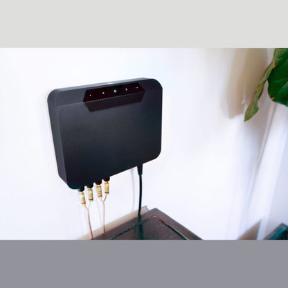 Bluesound Powernode EDGE Streaming-Verstärker Schwarz Lifestyle an der Wand montiert mit angeschlossenen Kabeln