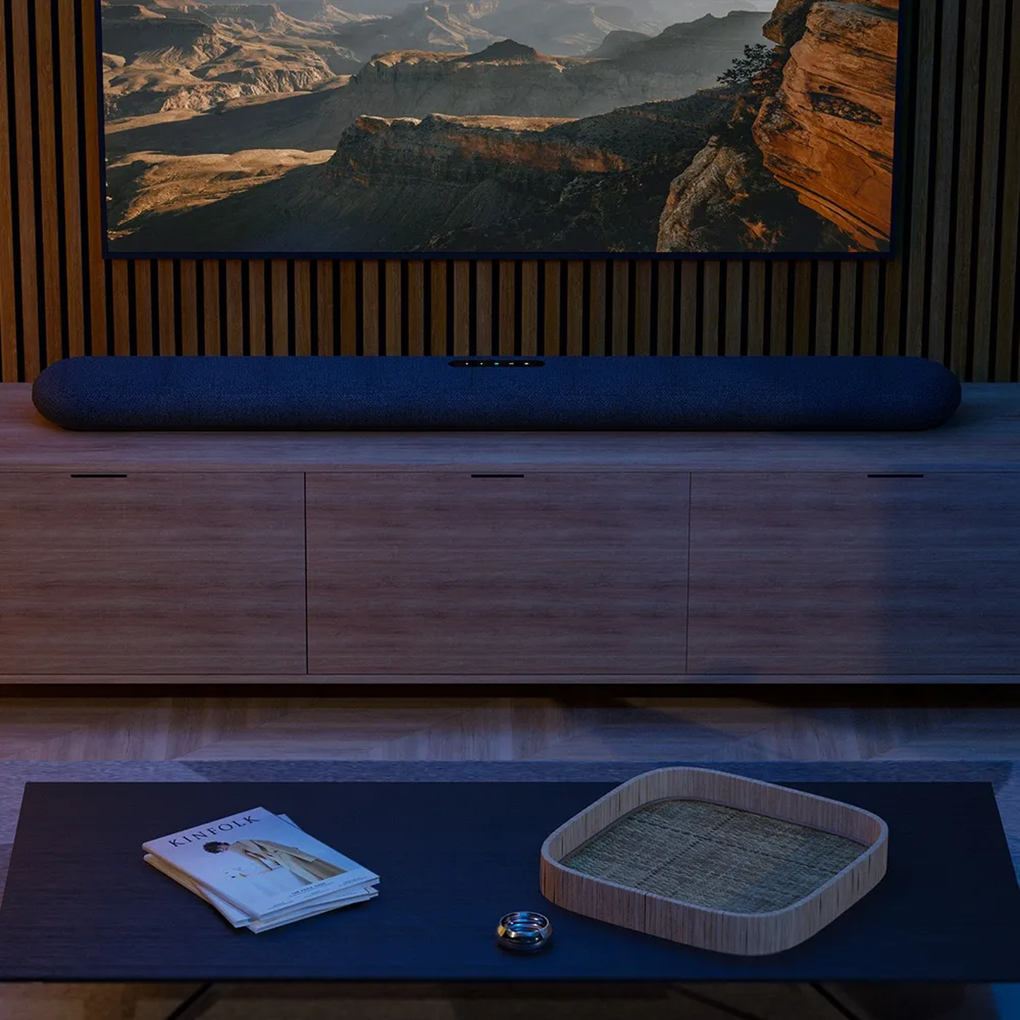 Bluesound Pulse Cinema Soundbar Schwarz Lifestyle im abgedunkelten Heimkino unter dem Fernseher