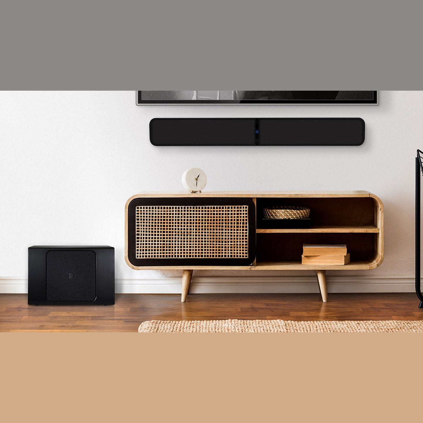 Bluesound Pulse Sub+ Subwoofer Schwarz Lifestyle liegend neben Sideboard unter Fernseher und Soundbar