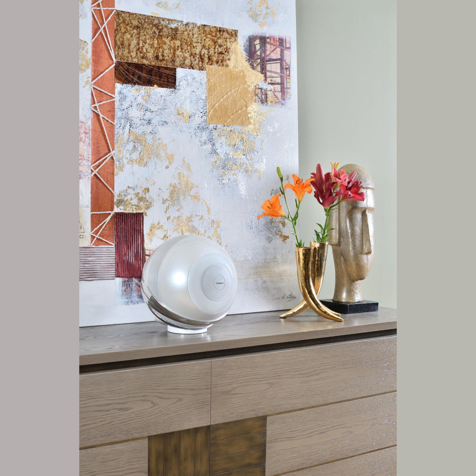 Cabasse The Pearl Aktivlautsprecher Lifestyle auf einem Sideboard vor einem Gemälde, Weiss