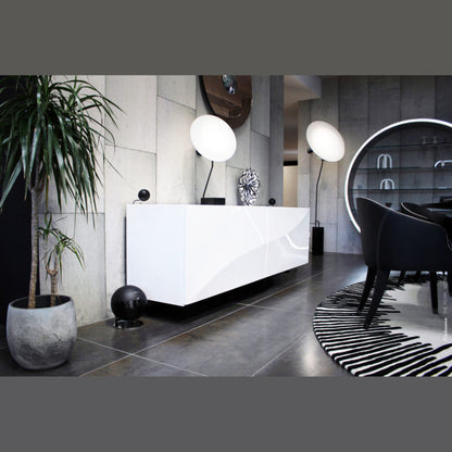 Cabasse The Pearl Keshi 2.1-System Lifestyle in Schwarz, Subwoofer am Boden neben weissem Empfangstresen