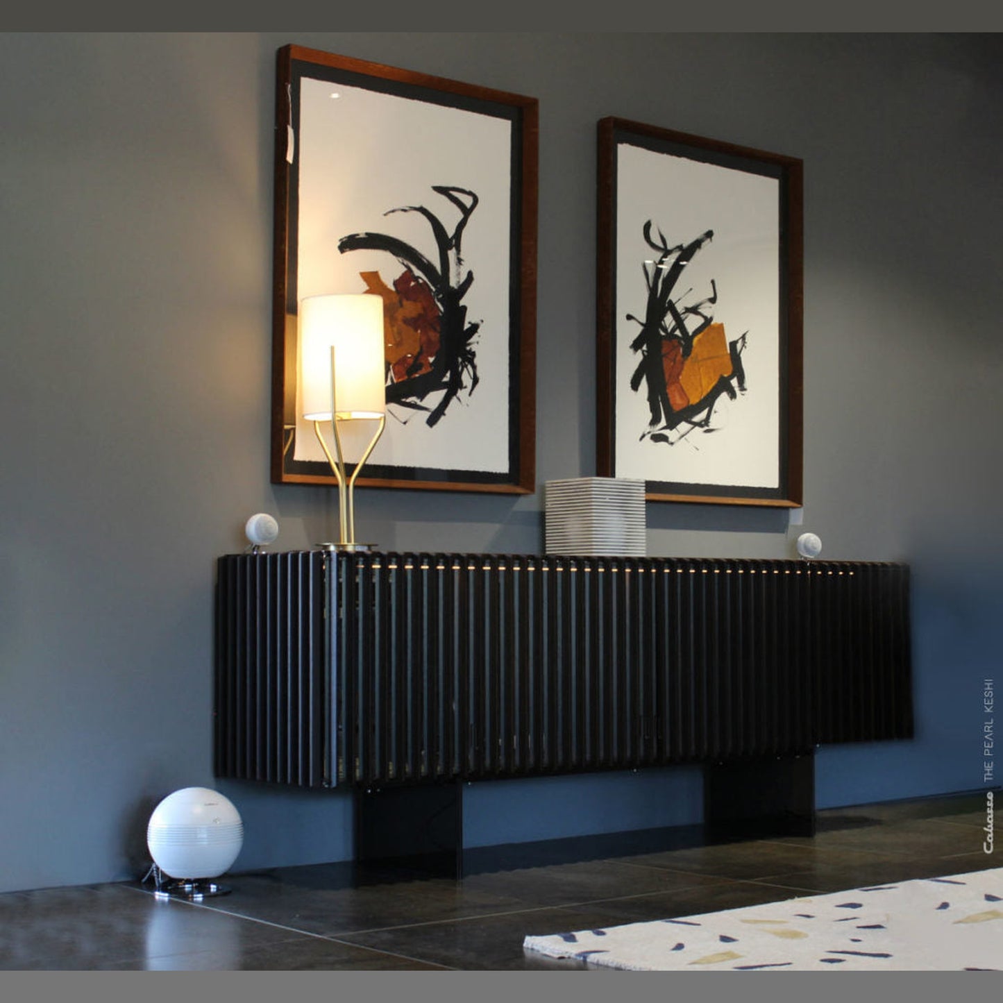 Cabasse The Pearl Keshi 2.1-System Lifestyle in Weiss an dunklem Lamellen-Sideboard unter zwei Bildern