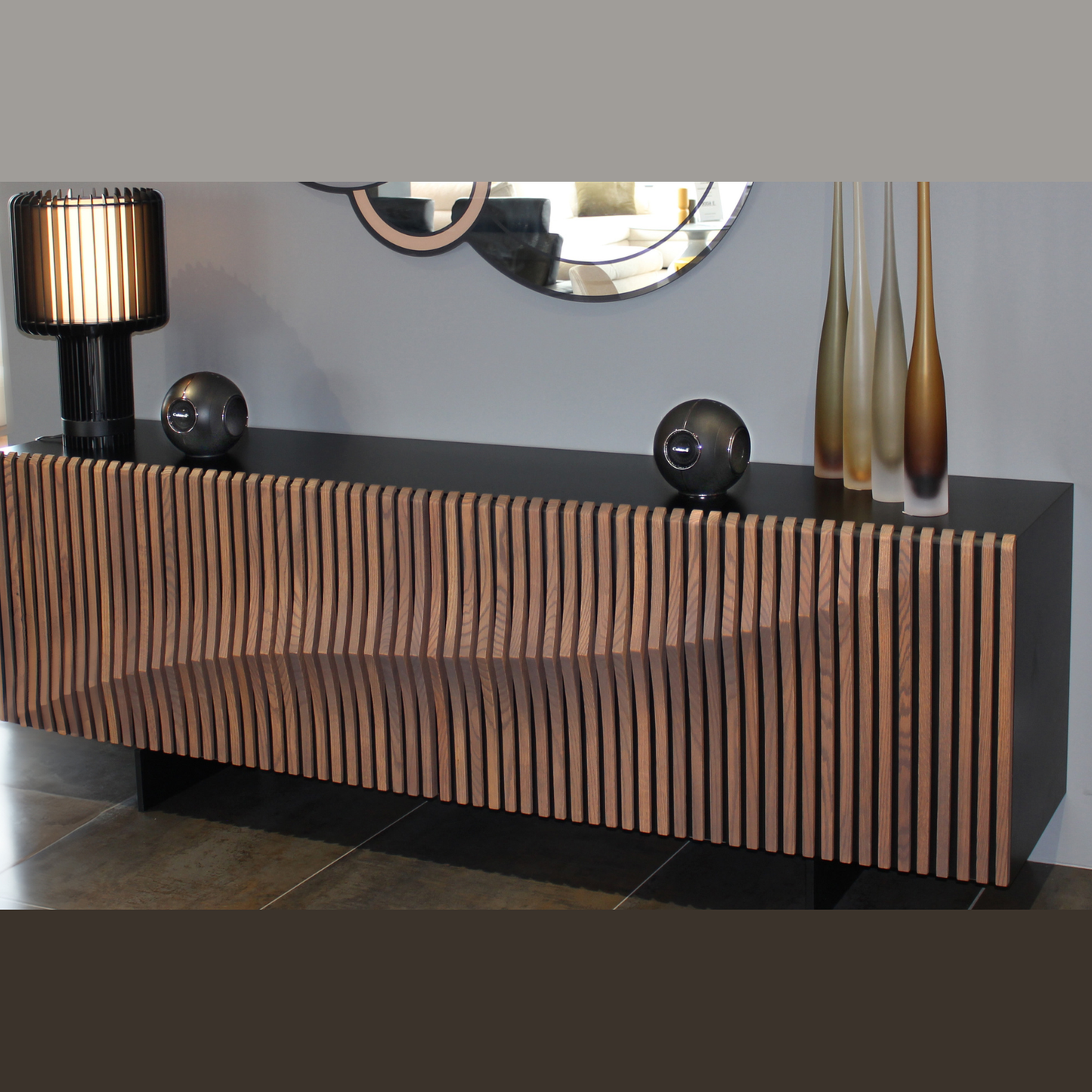 Cabasse The Pearl Myuki Aktivlautsprecher Lifestyle, Paar auf Lamellen-Sideboard im Wohnraum in Schwarz