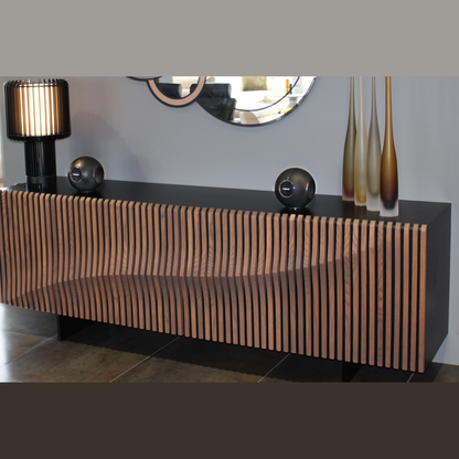 Cabasse The Pearl Myuki Aktivlautsprecher Lifestyle, Paar auf Lamellen-Sideboard im Wohnraum in Schwarz