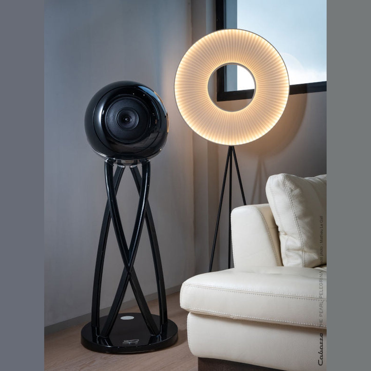 Cabasse The Pearl Pelegrina Standlautsprecher Lifestyle im Wohnraum neben Ringleuchte und Sofa in Schwarz