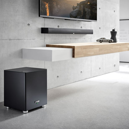 Canton Smart Soundbar 10 S2 Soundbar Schwarz Lifestyle an Betonwand mit Fernseher und Subwoofer
