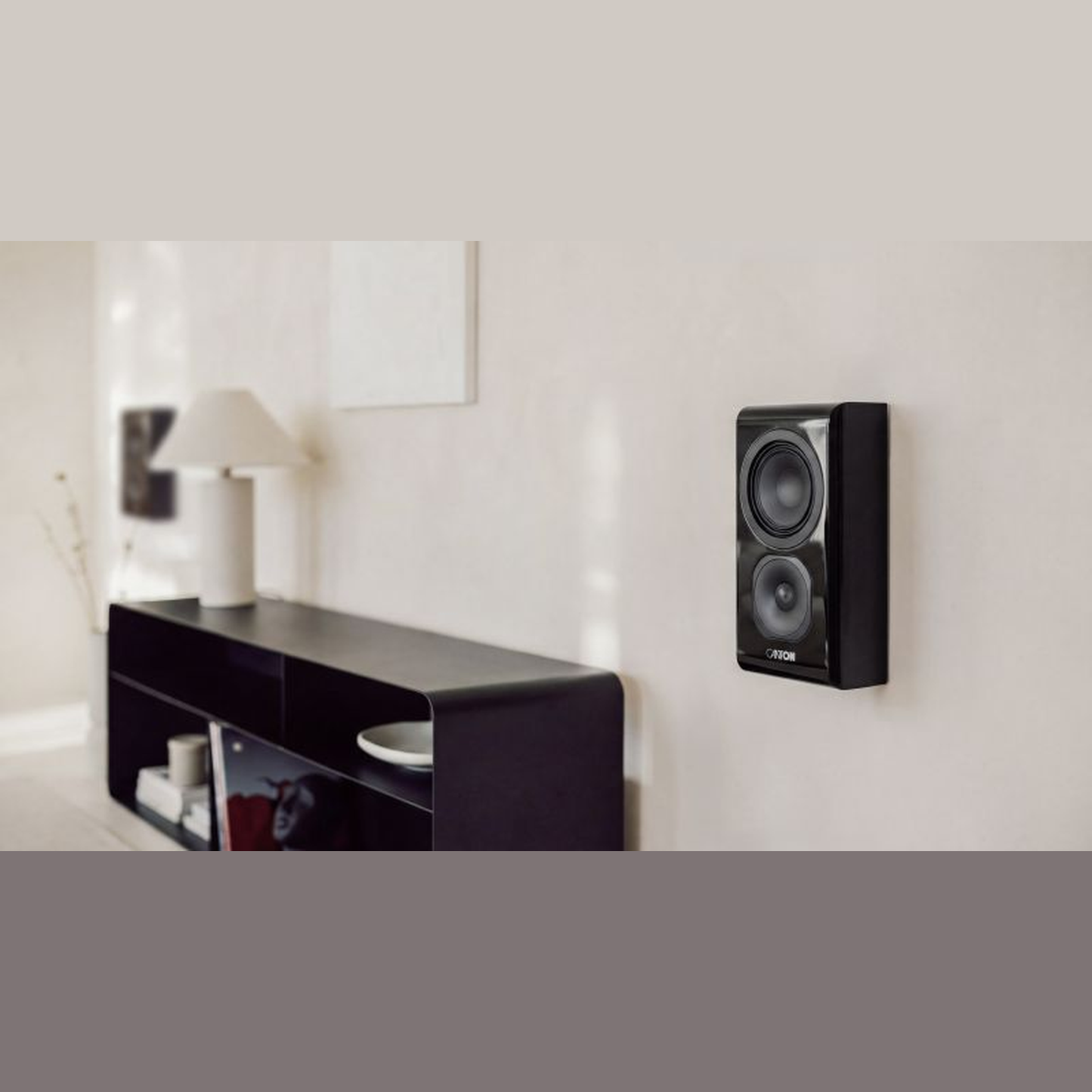 Canton Vento 11 Wandlautsprecher Schwarz Lifestyle an der Wand über dunklem Sideboard