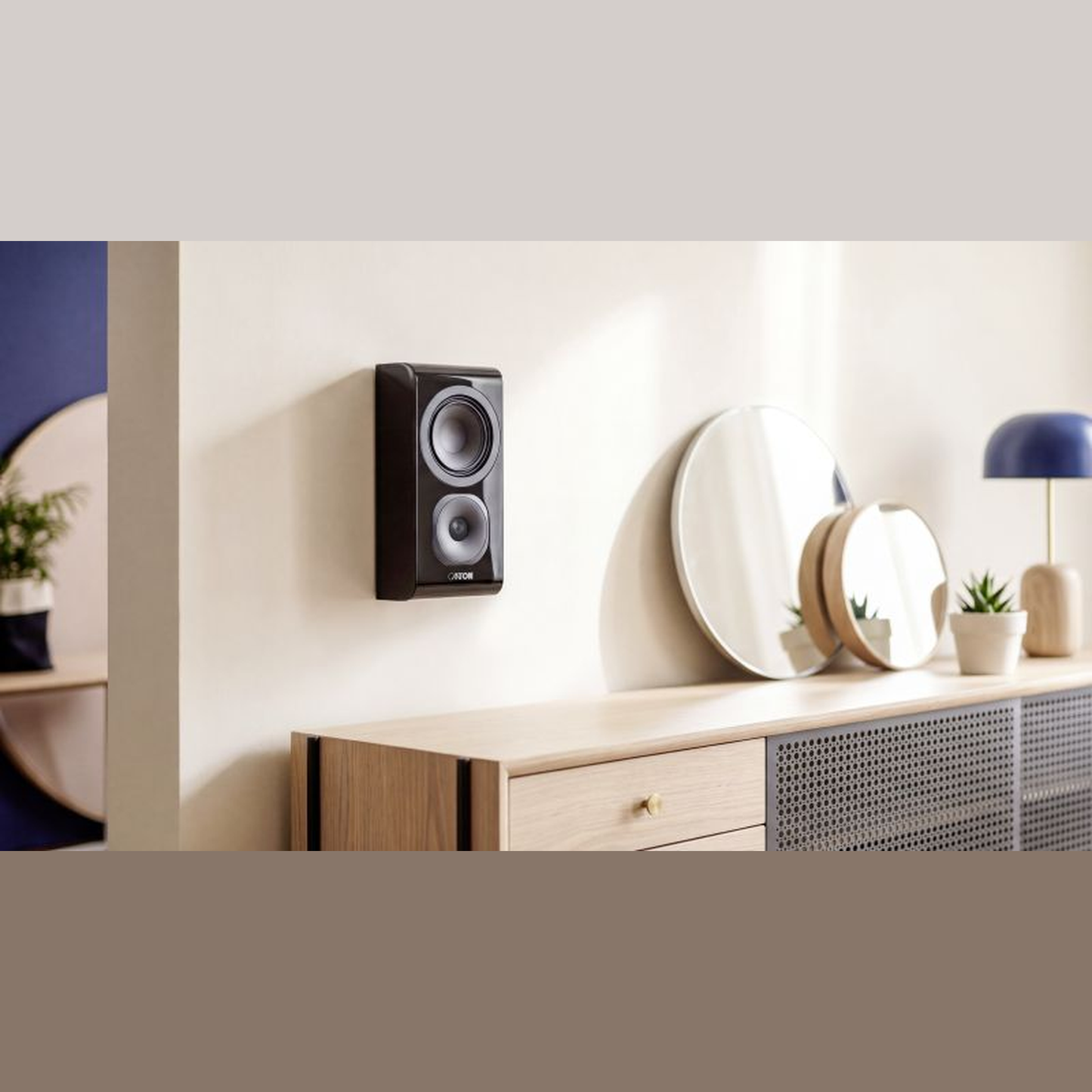 Canton Vento 11 Wandlautsprecher Schwarz Lifestyle an der Wand über einer Kommode mit Spiegeln
