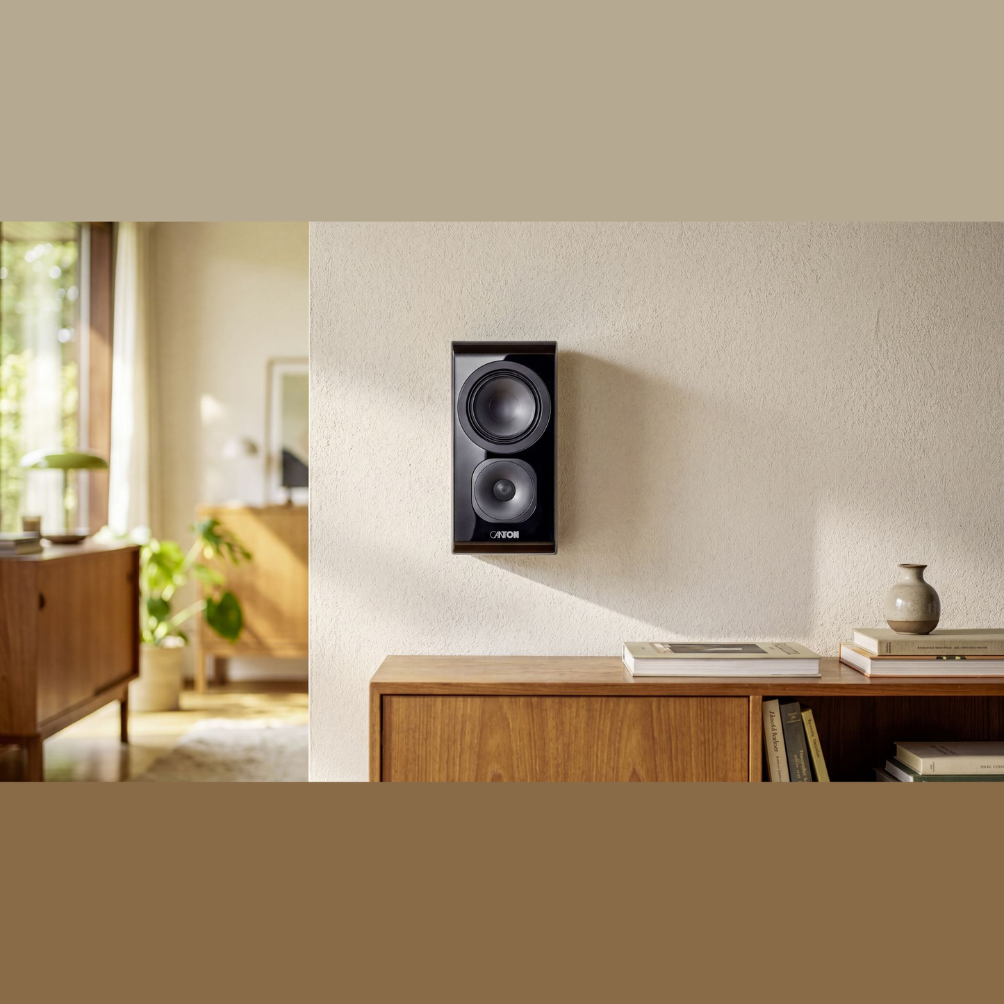 Canton Vento 11 Wandlautsprecher Schwarz Lifestyle an heller Wand über einem Sideboard