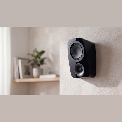 Canton Vento AR 1 Atmos-Lautsprecher Schwarz Lifestyle an heller Wand neben einem Wandregal