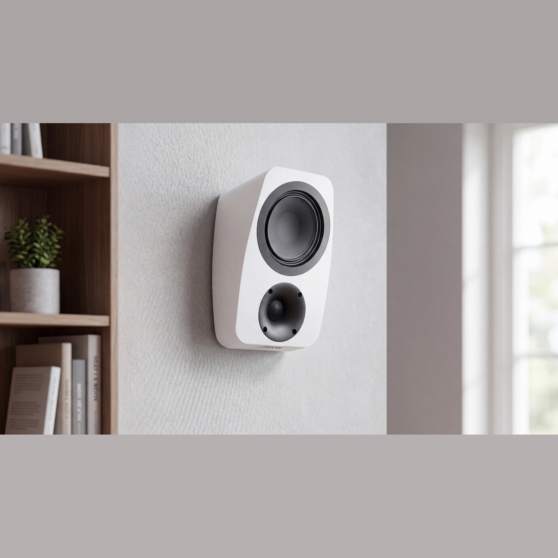 Canton Vento AR 1 Atmos-Lautsprecher Weiss Lifestyle an der Wand neben einem Bücherregal