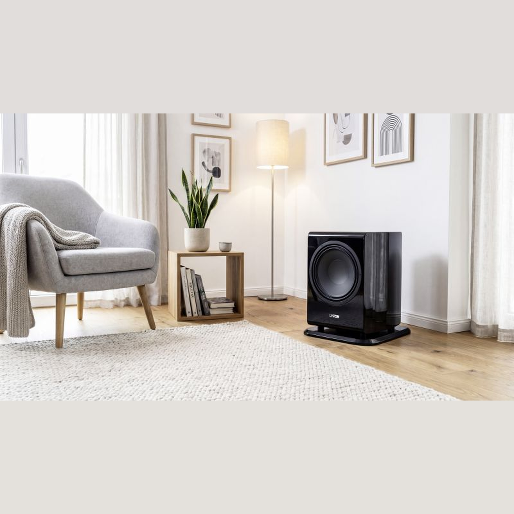 Canton Vento Sub 1 Aktiv-Subwoofer Lifestyle im Wohnzimmer mit Stehleuchte und Teppich, Schwarz