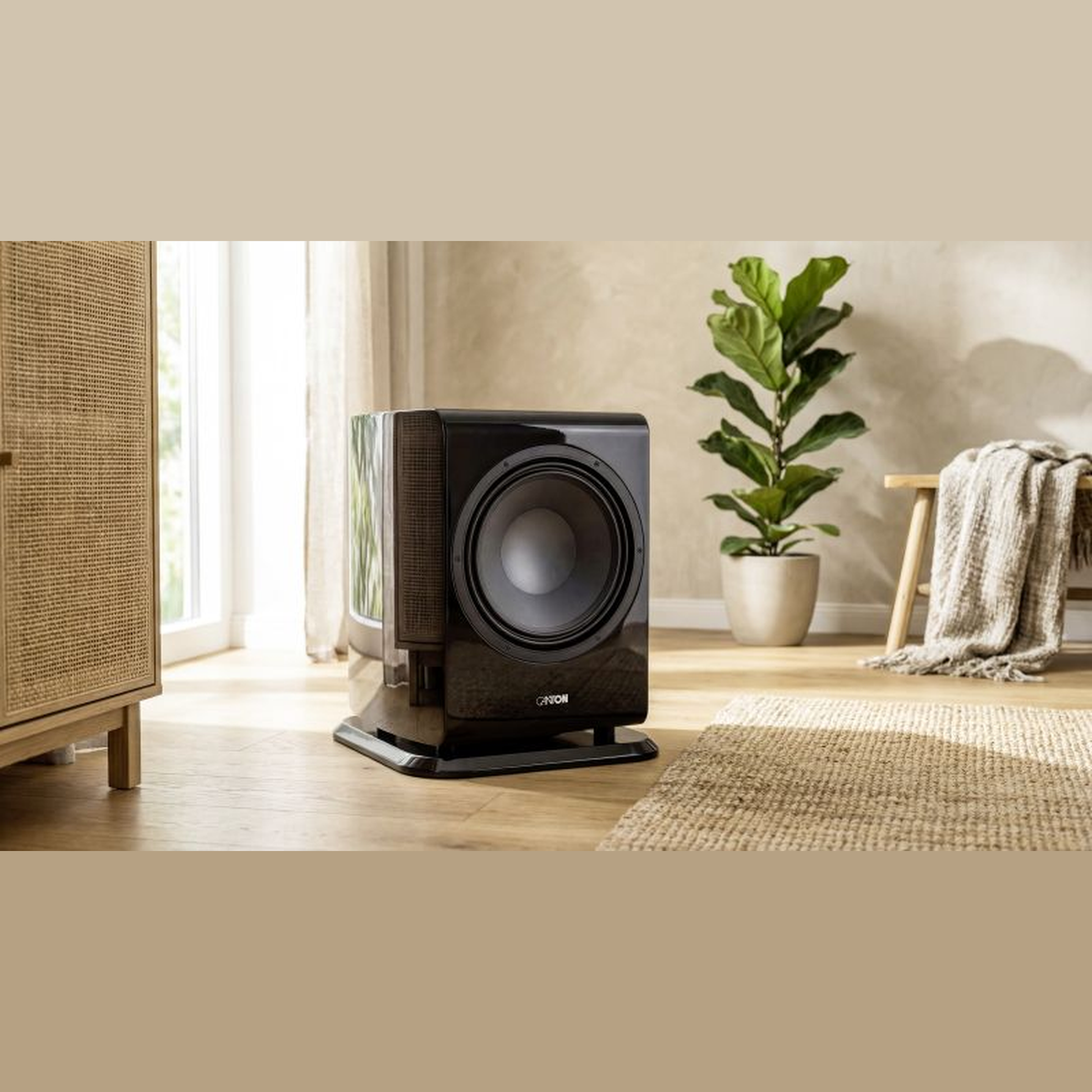 Canton Vento Sub 1 Aktiv-Subwoofer Lifestyle im Wohnraum neben Sideboard und Zimmerpflanze, Schwarz