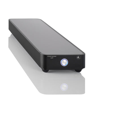 Clearaudio Smart Power 12V Akku-Netzteil Schrägansicht, schwarzes Flachgehäuse mit beleuchtetem Taster