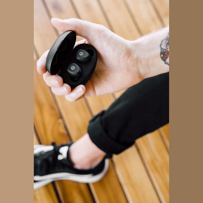 Grado GT220 True-Wireless-In-Ear-Kopfhörer Lifestyle geöffnete Ladebox in einer Hand über Holzterrasse