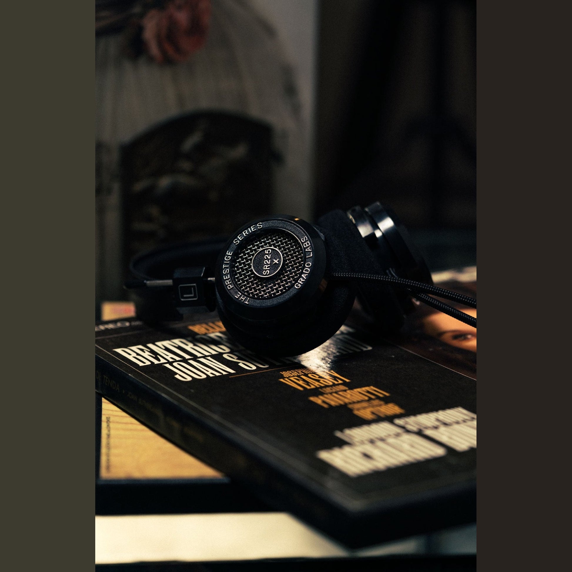 Grado Prestige SR225x Open-Back-Kopfhörer Lifestyle auf einem Stapel Schallplattenhüllen