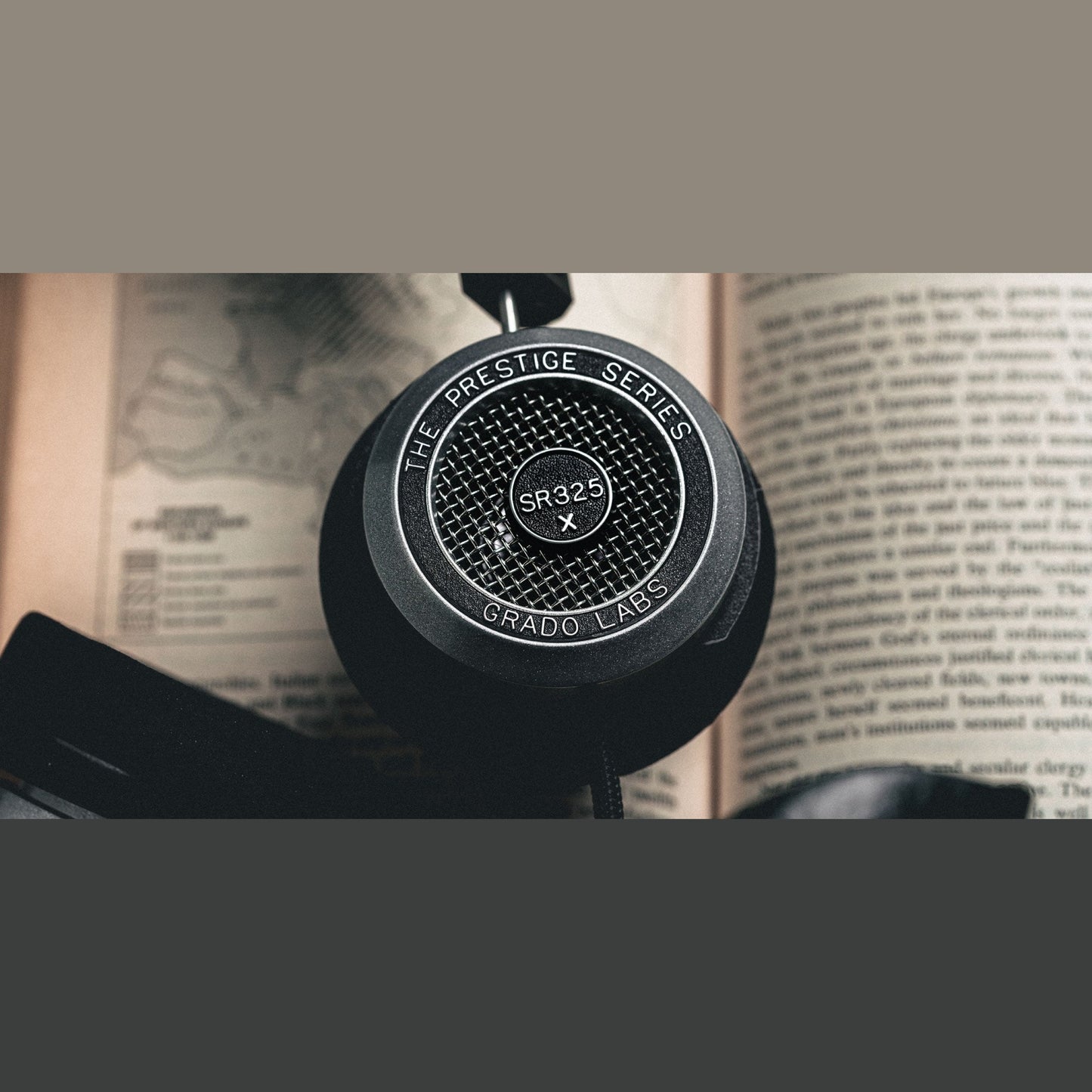 Grado Prestige SR325x Open-Back-Kopfhörer Lifestyle Nahaufnahme der Ohrmuschel auf einem Buch