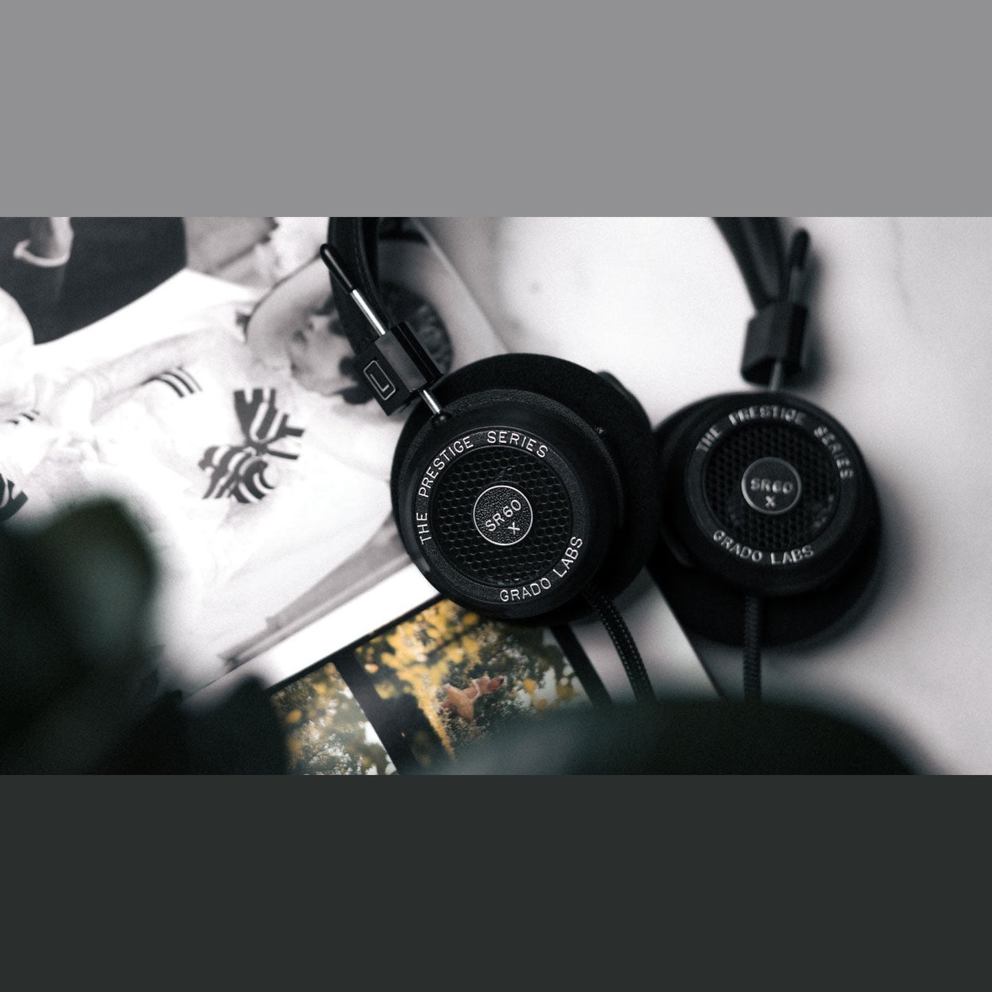 Grado Prestige SR60x Open-Back-Kopfhörer Lifestyle mit beiden Ohrmuscheln auf bedruckten Papierbögen