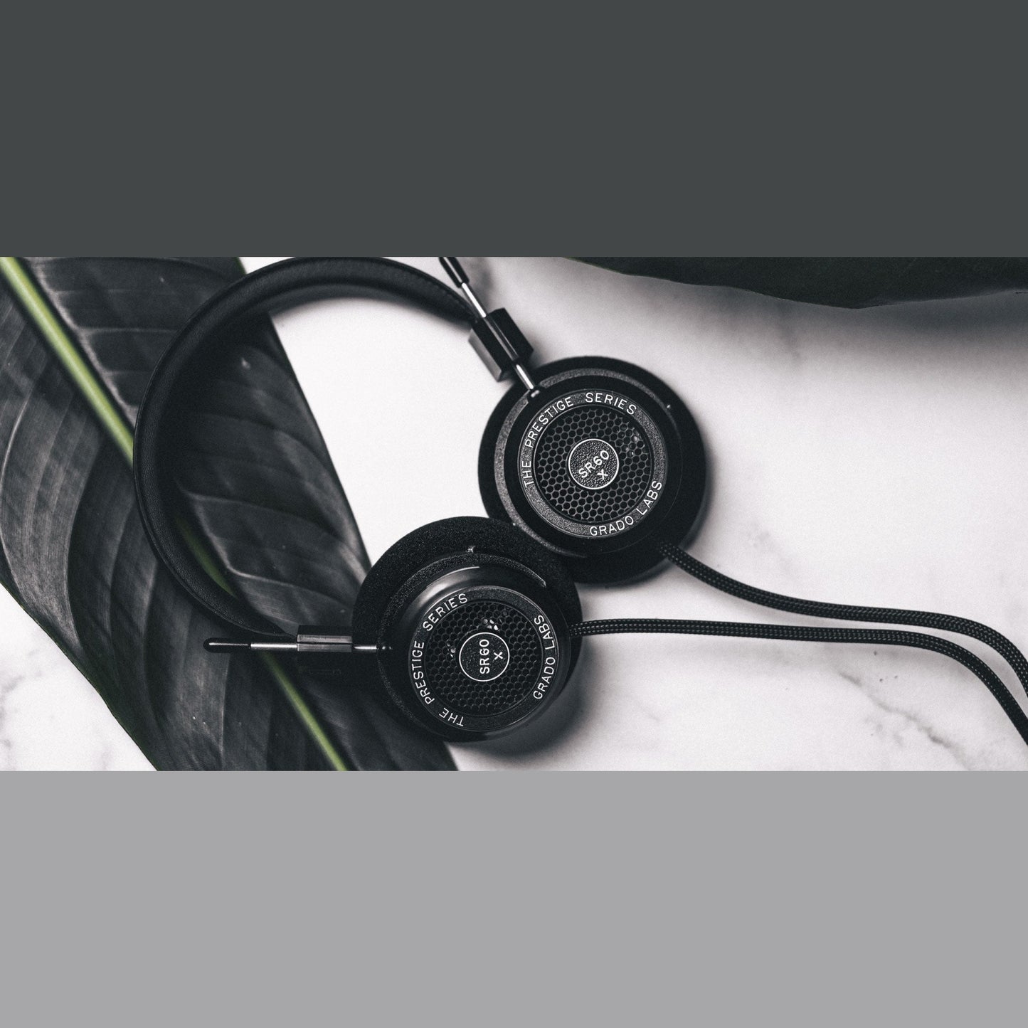 Grado Prestige SR60x Open-Back-Kopfhörer Lifestyle auf Marmor neben einem dunklen Blatt