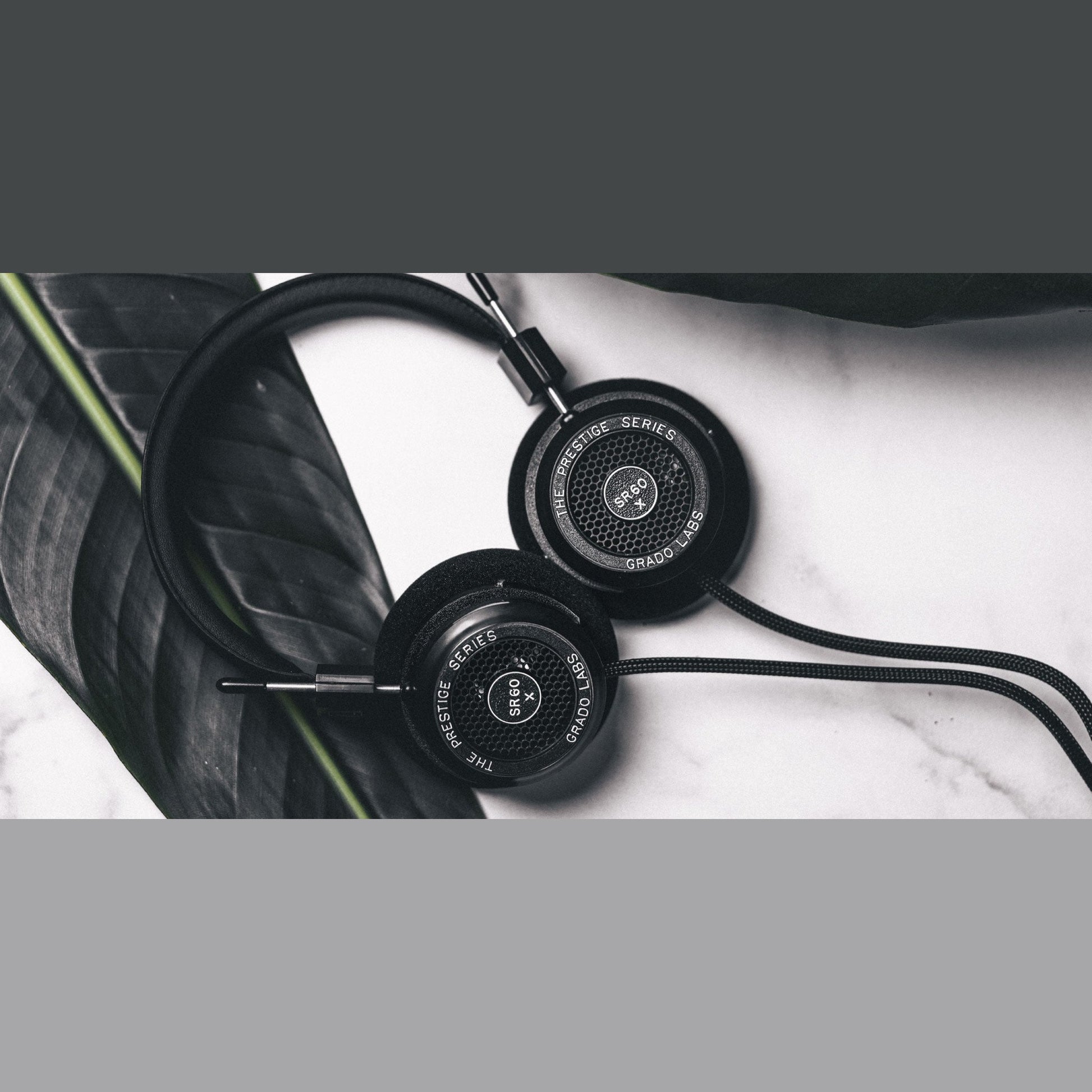 Grado Prestige SR60x Open-Back-Kopfhörer Lifestyle auf Marmor neben einem dunklen Blatt