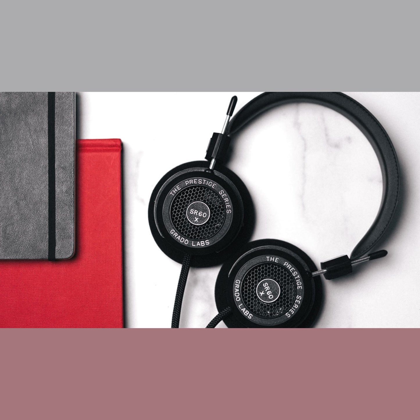 Grado Prestige SR60x Open-Back-Kopfhörer Lifestyle auf Marmor neben roten und grauen Notizbüchern