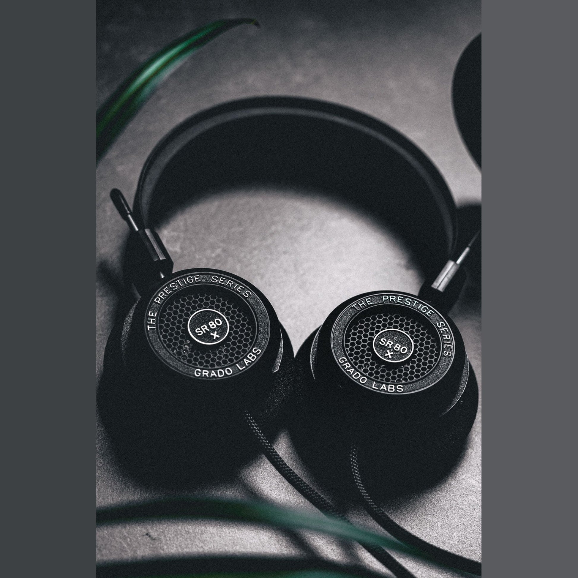 Grado Prestige SR80x Open-Back-Kopfhörer Lifestyle mit beiden Ohrmuscheln auf grauem Betonuntergrund