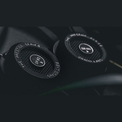 Grado Prestige SR80x Open-Back-Kopfhörer Lifestyle Nahaufnahme beider Ohrmuscheln vor dunklem Hintergrund