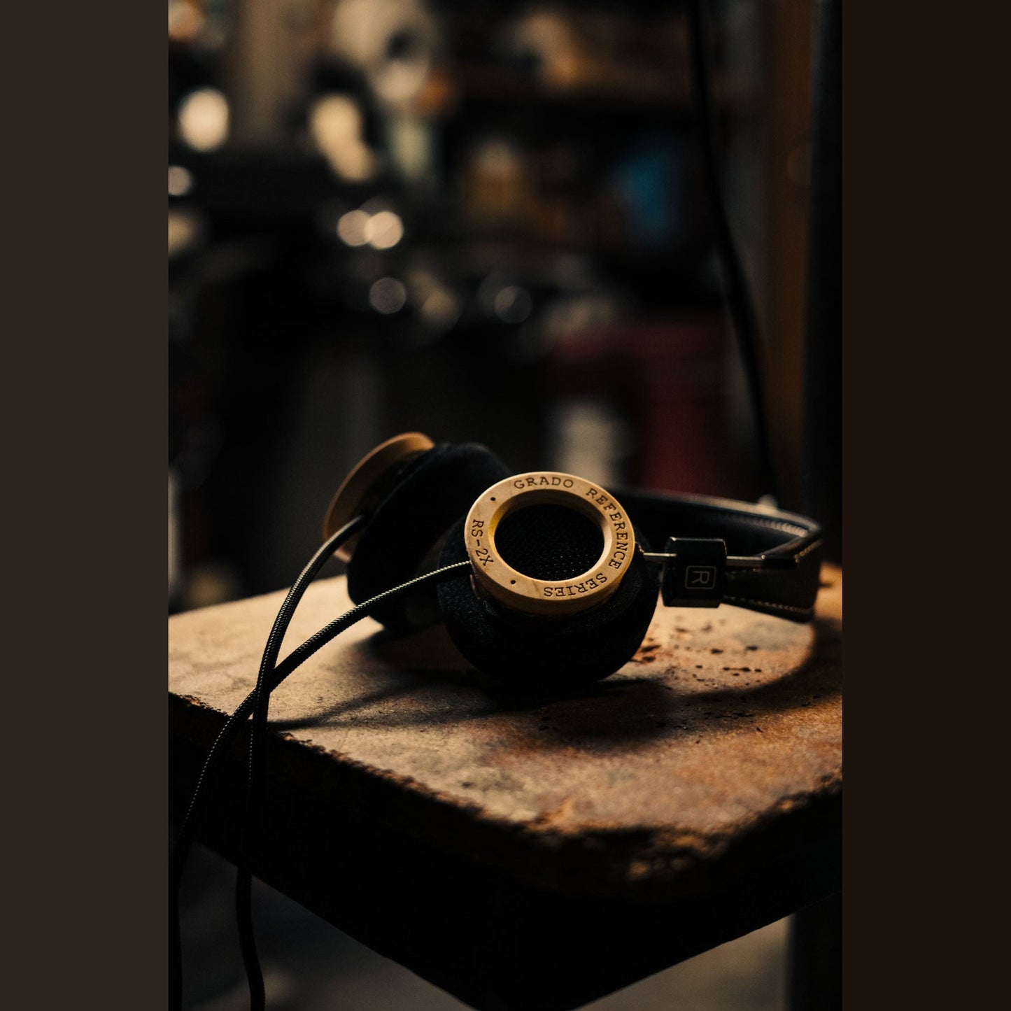 Grado Reference RS2x Open-Back-Kopfhörer Lifestyle auf rostiger Metallplatte vor unscharfem Werkstattregal