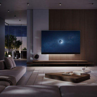 Loewe Stellar 97 DR+ OLED-Fernseher alu matt Vidaa im dunklen Wohnzimmer, Lifestyle