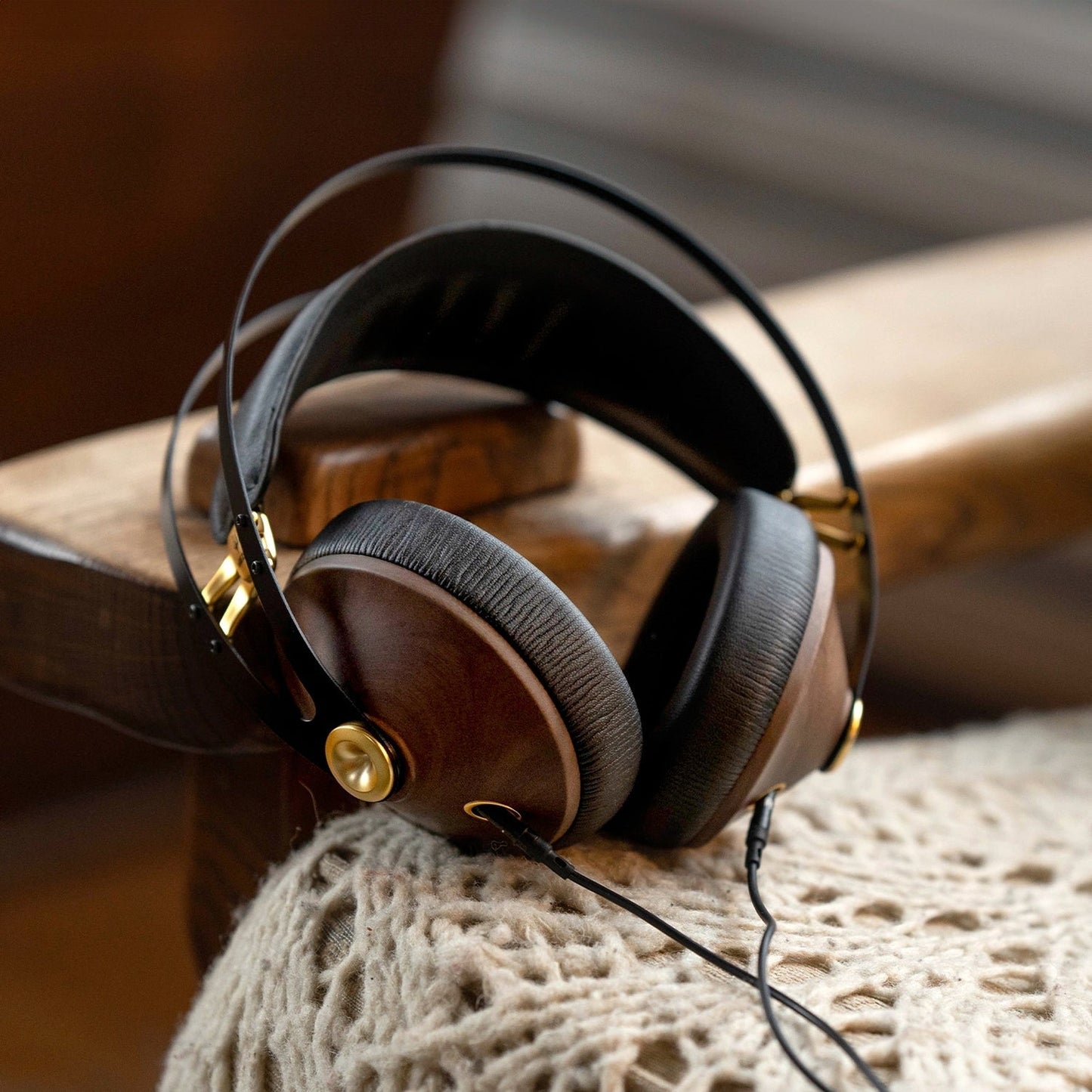 Meze Audio 99 Classics 2. Gen Kopfhörer Walnuss-Gold Lifestyle auf einer Holzbank