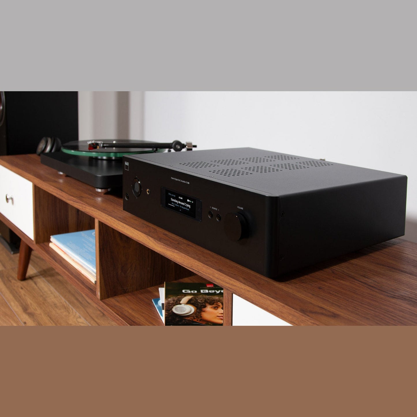 NAD C399 Vollverstärker Lifestyle Nahaufnahme auf Sideboard mit Kopfhörer