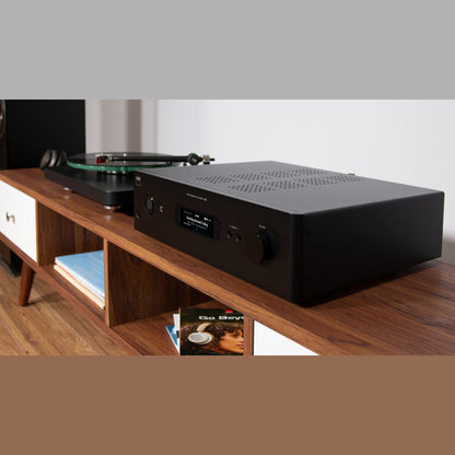 NAD C399 Vollverstärker Lifestyle Nahaufnahme auf Sideboard mit Kopfhörer