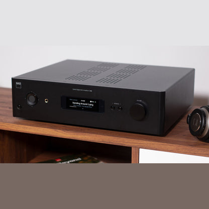 NAD C399 Vollverstärker Lifestyle im Wohnzimmer neben Plattenspieler und Kopfhörer
