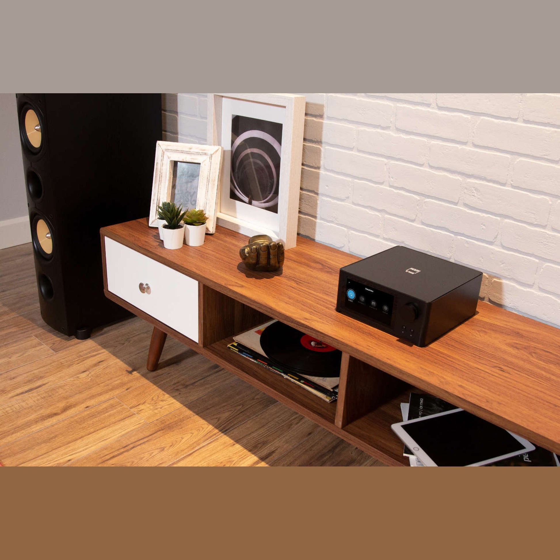 NAD C700 V2 BluOS Streaming-Vollverstärker Lifestyle 5 auf Sideboard mit Vinyl-Sammlung